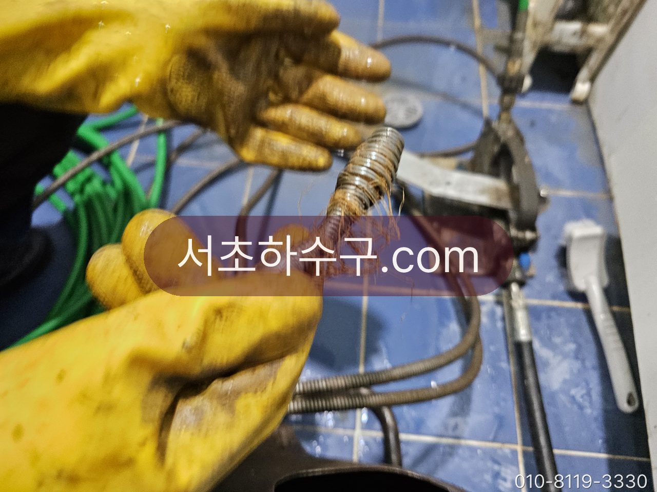 장갑 낀 손에 든 스프링 관통기 헤드와 배관 작업 장비