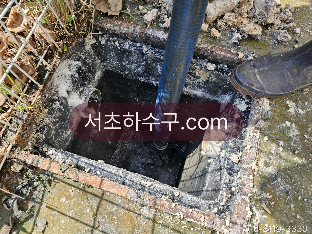 마당 우수받이 통 안으로 고압 호스를 넣어 연결관을 세척하는 작업