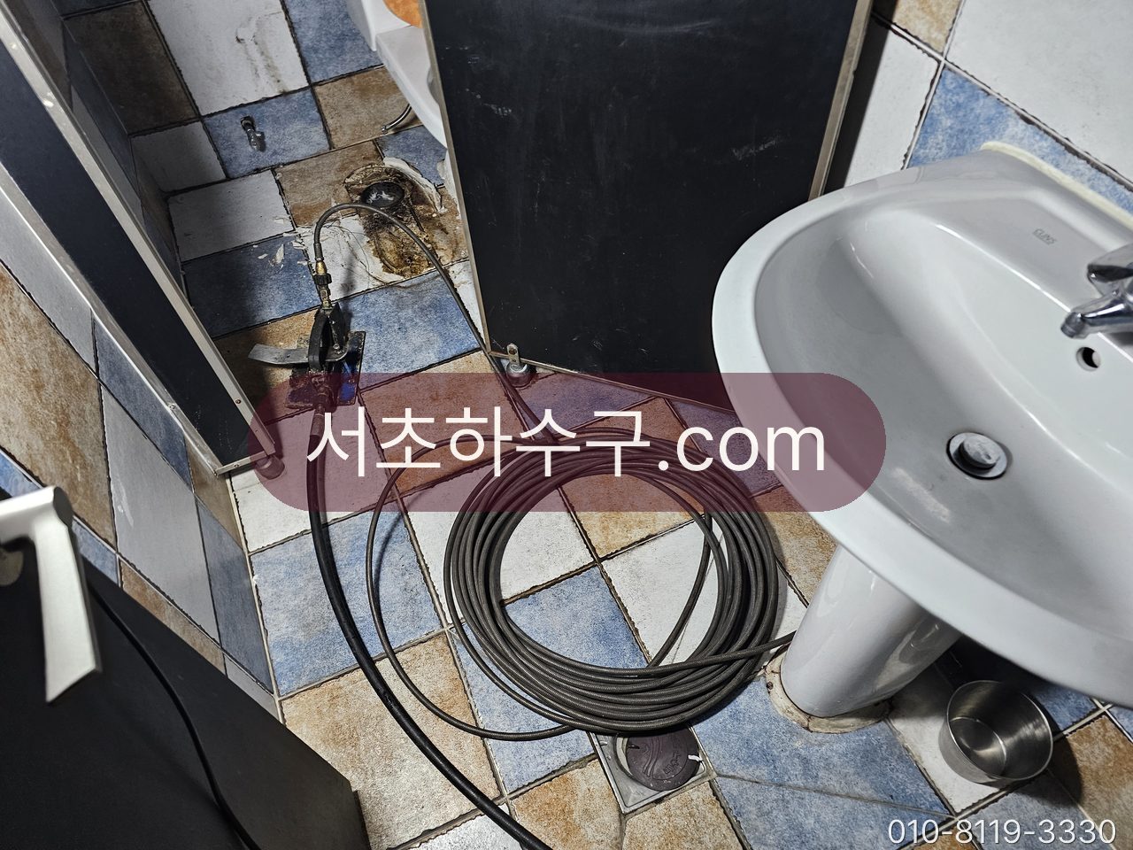 세면대 옆 바닥에 관통 케이블을 풀어 놓고 배수관을 뚫는 작업