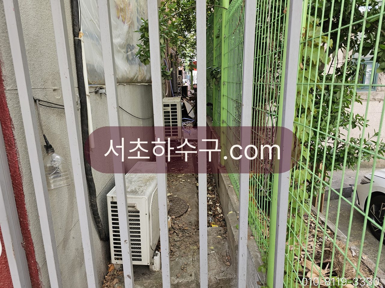 건물 외벽 실외기 옆으로 나온 에어컨 배수 호스 끝